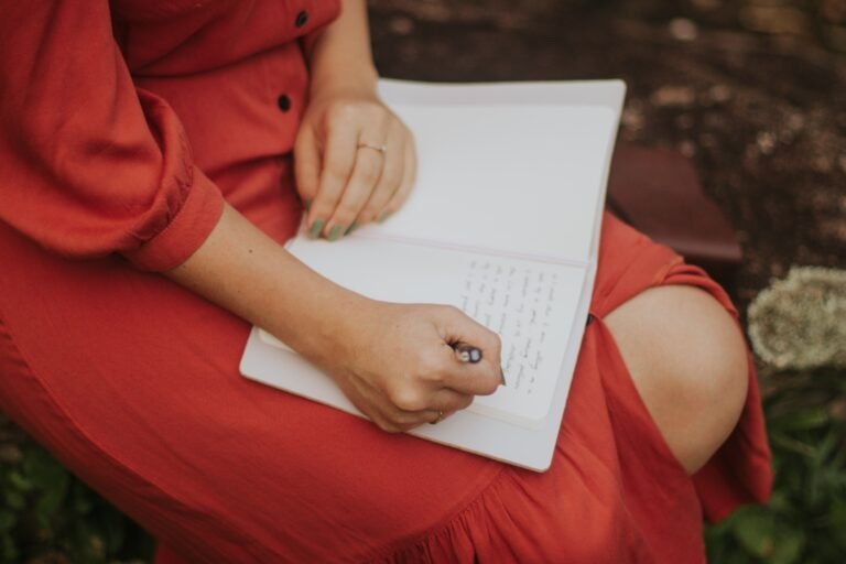 Mujer escribiendo en su libreta sobre el jardin